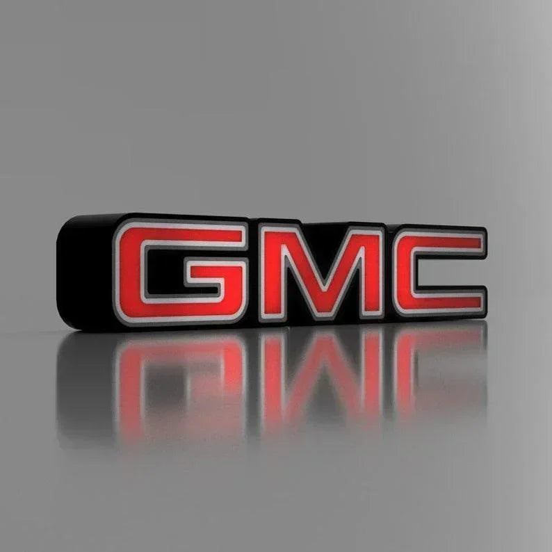 A 3D printed LED light box sign featuring the GMC car logo with red and black colors on a reflective surface.